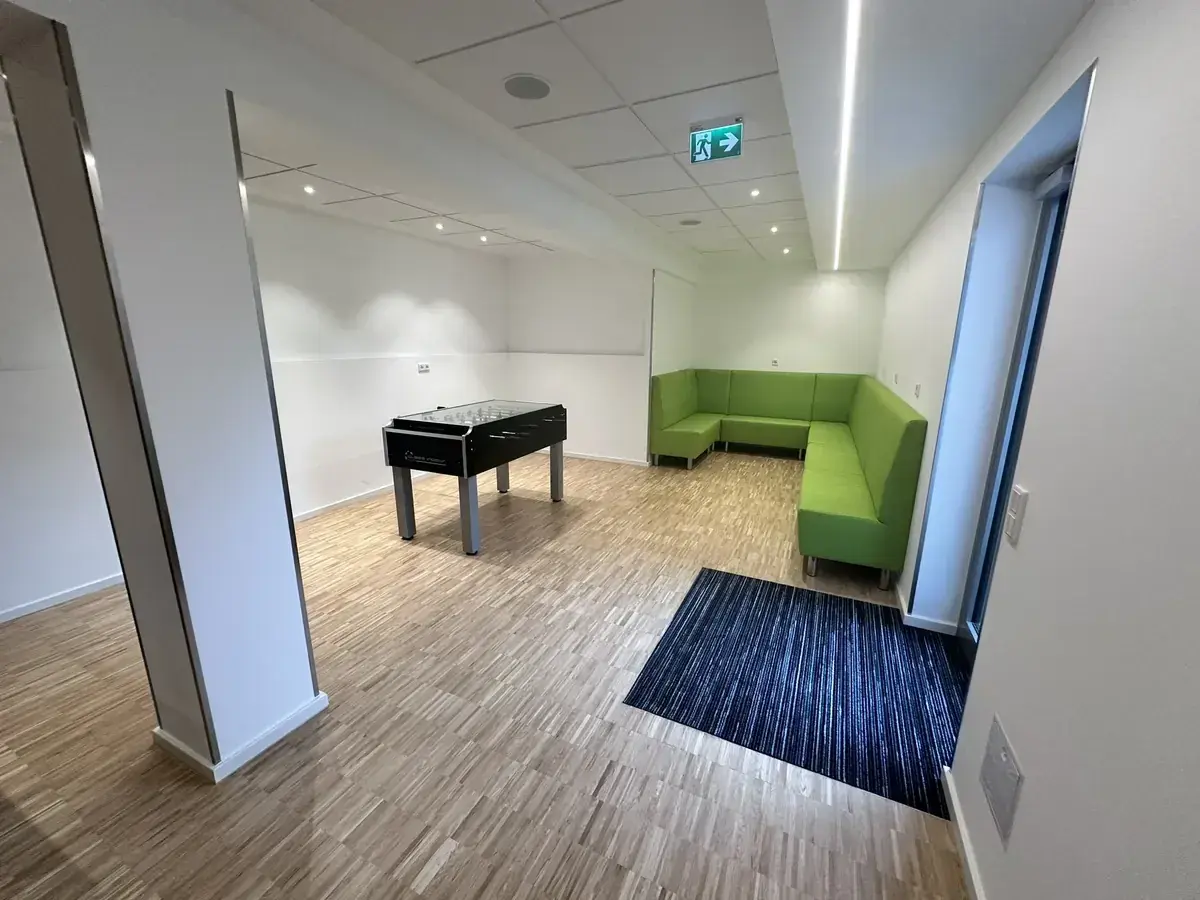 Aufenthaltsraum mit weiß gestrichenen Wänden und Decke