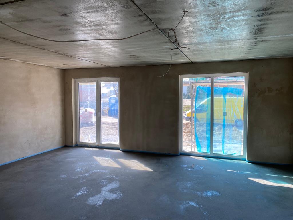 Heller Innenraum mit großen Fenster- und Terrassentüren – Fenstermontage von Dilmac Bau