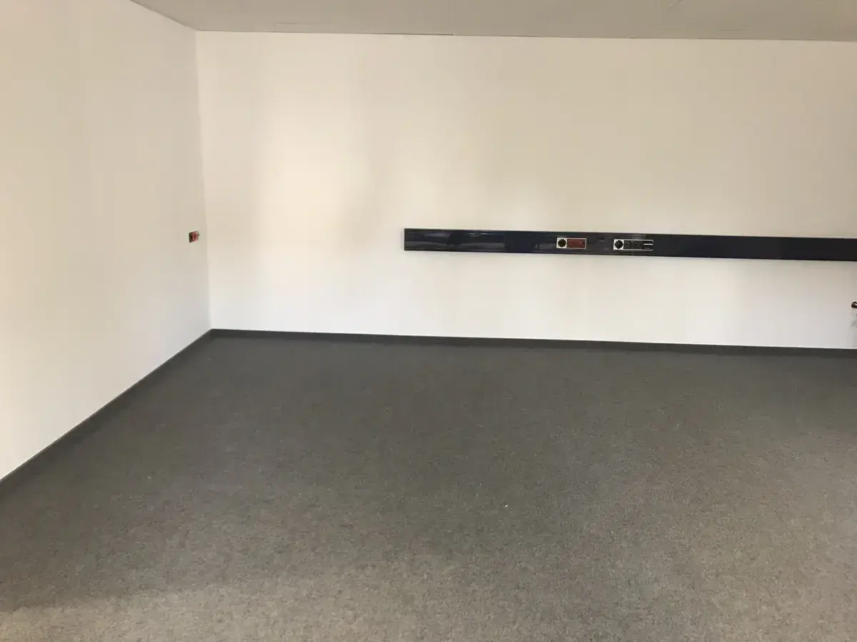 Büroraum mit frisch weiß gestrichenen Wänden und dunklem Wandband
